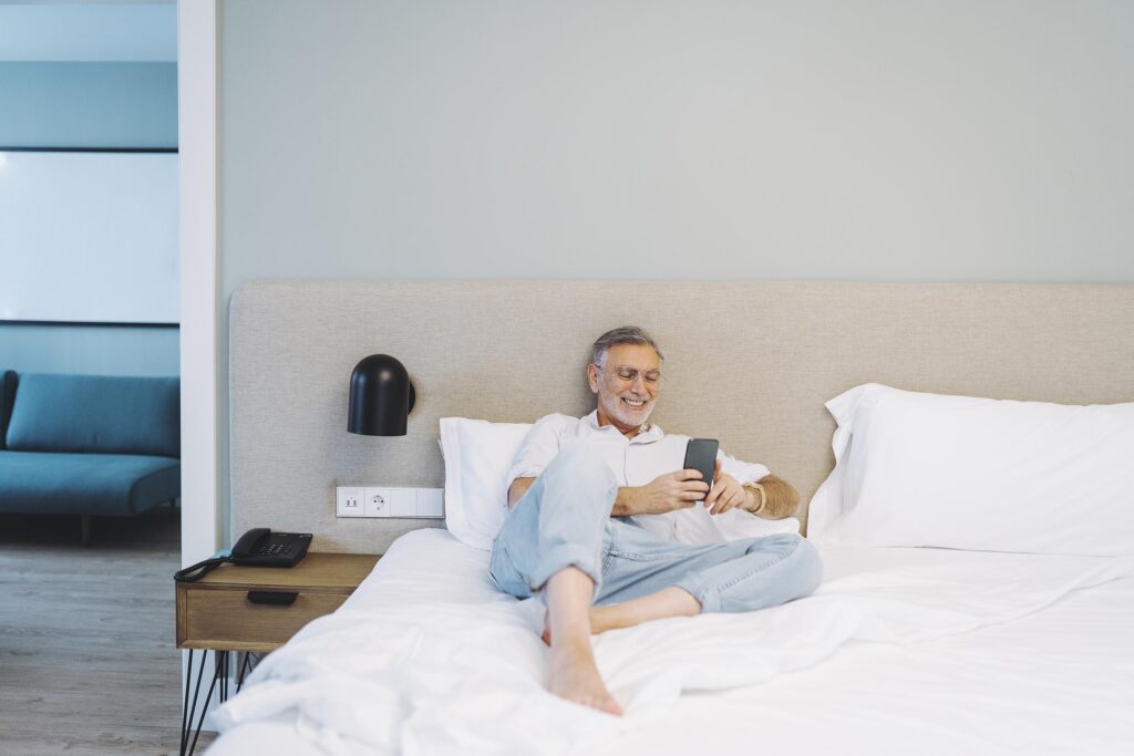 Un hombre descansando en la cama del hotel