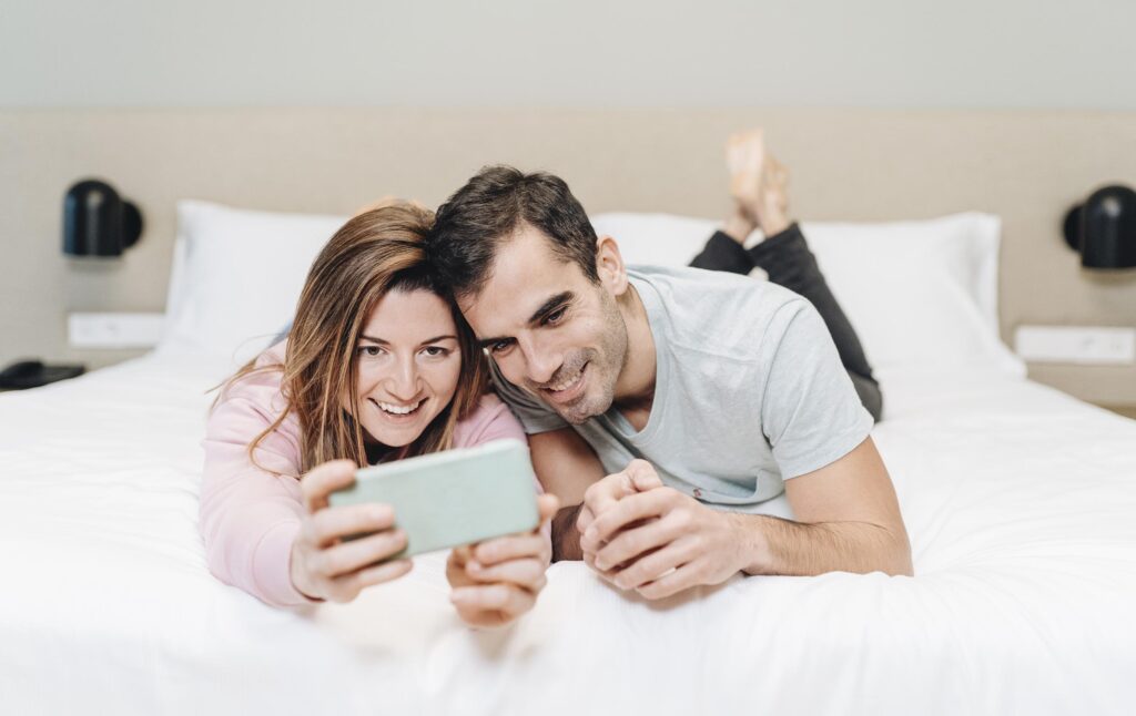 Pareja haciéndose una fotografía en una habitación de hotel